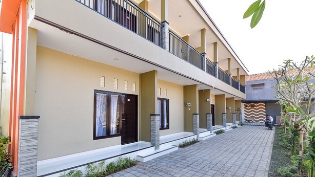 A modern building with a flat roof, a central courtyard, and a covered walkway.