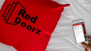 A red pillow with the text "Red Doorz" on a white surface. - RedDoorz @ Galuh Mas (Karawang)