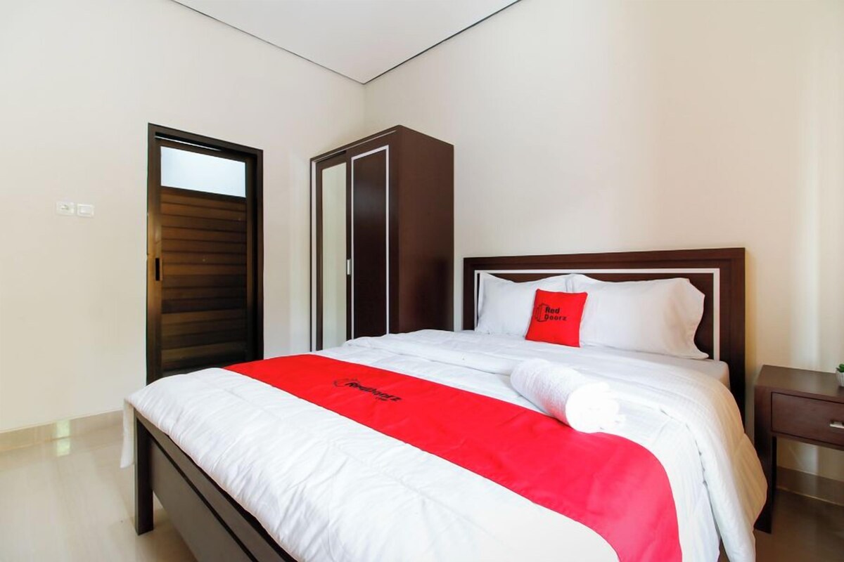 A hotel room with a bed, a wardrobe, and a nightstand.
