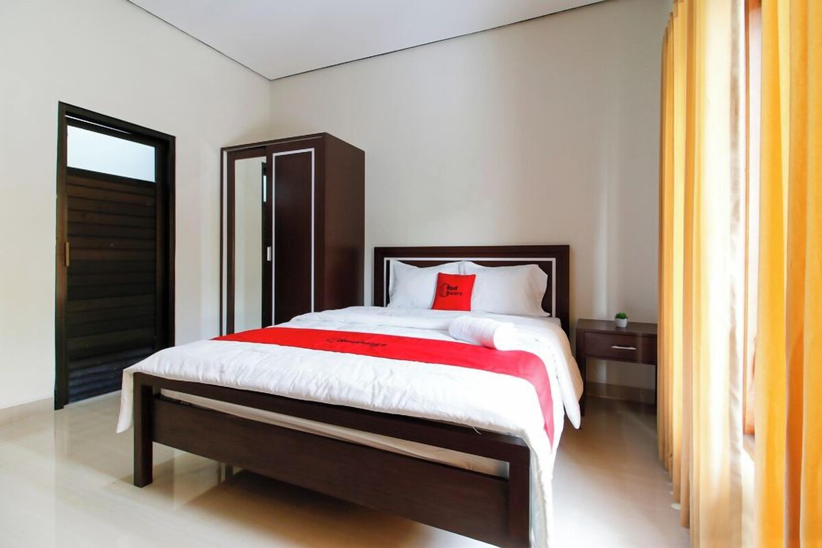 A modern bedroom with a bed, a wardrobe, and a nightstand.