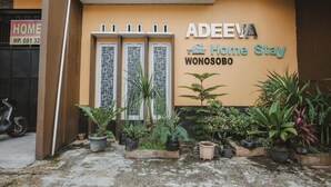 Un edificio con un cartello che riporta la scritta "ADEEVA Home Stay WONOSOBO".