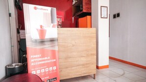 A RedDoorz sign with a service guarantee and a Google Play logo. - RedDoorz near Palembang Square Mall 2 (Palembang)