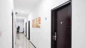 A hallway with doors numbered 52 and 53, white walls, and a tiled floor.