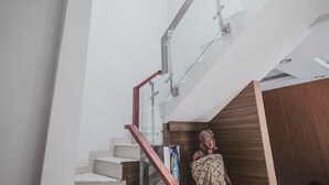 A modern staircase with glass railings and wooden accents. - RedDoorz @ Jamin Ginting Medan (Medan)