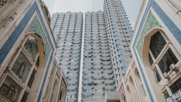 A tall, modern building with a grid of windows and balconies. - RedDoorz Apartment @ Saladin Mansion Margonda (Depok)