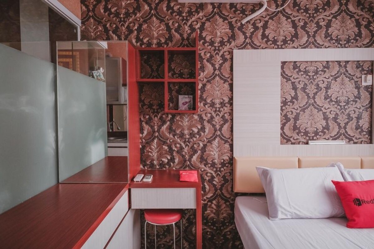 Une chambre d’hôtel moderne, dotée d’un bureau, d’un lit avec une tête de lit et d’un papier peint à motifs.