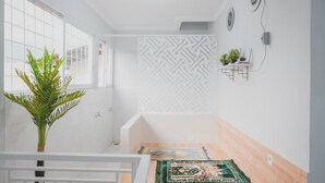 Een moderne badkamer met een groot raam, een douchegedeelte en een behang met een patroon.