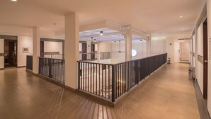 A spacious hotel corridor with a central railing, recessed lighting, and a modern ceiling design. - RedDoorz Plus @ Cipaganti Street 3 (Bandung)