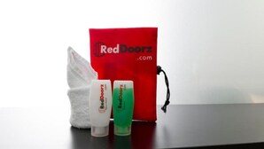 A RedDoorz bag, a white tissue, and a green bottle on a table. - RedDoorz @ Tebet Barat 2 (Jakarta)