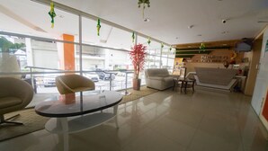 A modern lobby with a glass partition, a round table, and seating areas. - RedDoorz Apartment near Bundaran Satelit Surabaya (Surabaya)
