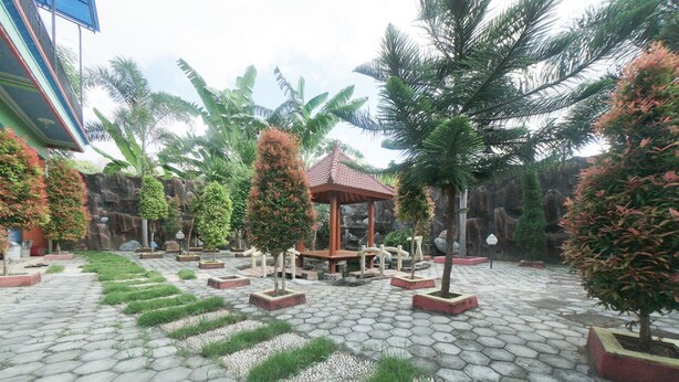 A courtyard with a gazebo, potted plants, and a stone-tiled floor. - RedDoorz Syariah near Mall Roxy Banyuwangi 2 (Banyuwangi)