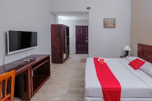 Una habitación de hotel con cama, televisión, escritorio y armario.
