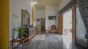A hallway with a wooden cabinet, a potted plant, a mirror, and a small table.