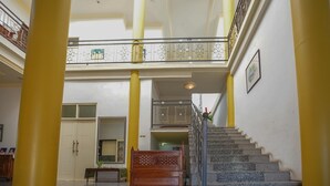 A multi-level interior with a staircase, a balcony, and a bed.