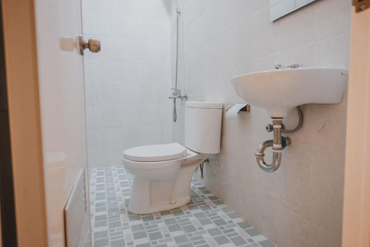 Une salle de bain avec des toilettes, une douche et un lavabo.
