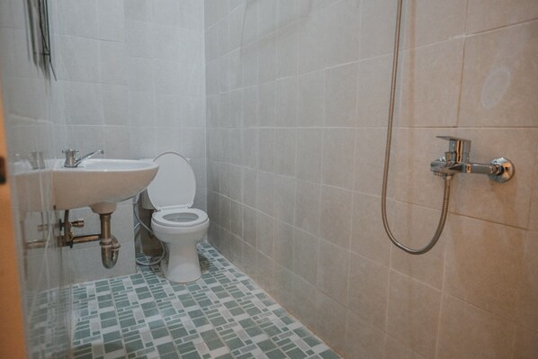 A bathroom with a toilet, sink, and shower. - RedDoorz Plus near Plaza Blok M (Jakarta)