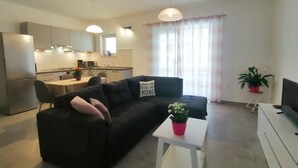 A modern apartment with a living room, kitchen, and dining area. - Holiday apartment "Dunja", only 500m from the beach (Pula)