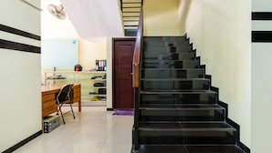 Un escalier avec des marches noires menant à un palier.