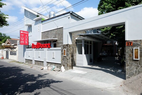 Un bâtiment moderne orné du logo RedDog, doté d’une façade en pierre et d’une entrée de garage.