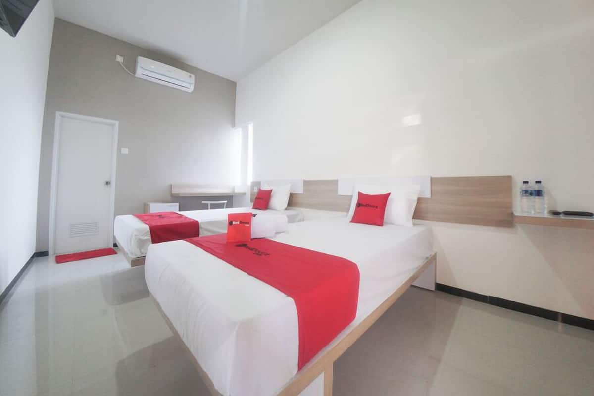 Een moderne hotelkamer met een groot bed, een nachtkastje, een stoel en een klein bureau.