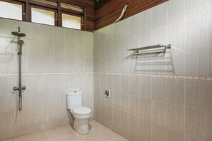 A small bathroom with a toilet, a shower, and a towel rack. - RedDoorz Resort @ Taman Wisata Mangrove (Jakarta)