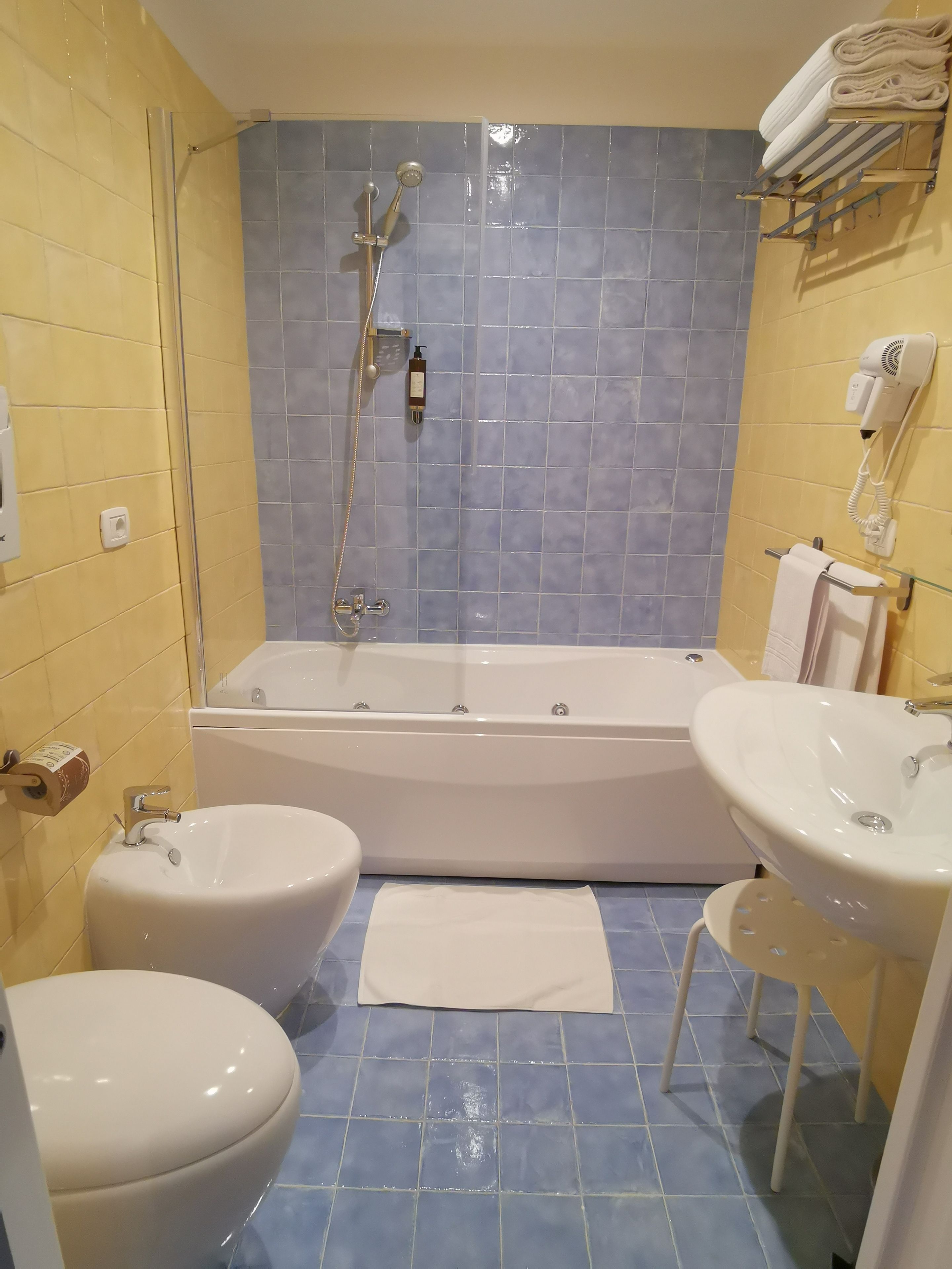 A bathroom with a bathtub, two sinks, a toilet, and a shower.