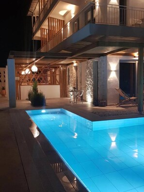 Una piscina al aire libre, sillones reclinables de piscina