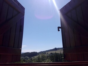 Una estructura de madera abierta con vista a un paisaje montañoso.