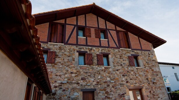Un edificio de piedra con techo inclinado y vigas de madera.