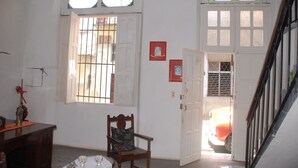 A room with a wooden chair, a small table, and a window with bars. - Alameda dePaula (Havana)