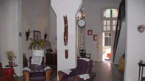 A spacious living room with a large armchair, a small table with a vase, and a potted plant. - Alameda dePaula (Havana)