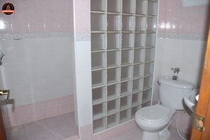 A bathroom with a toilet, a shower enclosure, and a sink. - Alameda dePaula (Havana)