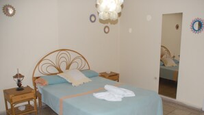 A bedroom with a bed, a nightstand, a mirror, and decorative wall art. - Alameda dePaula (Havana)