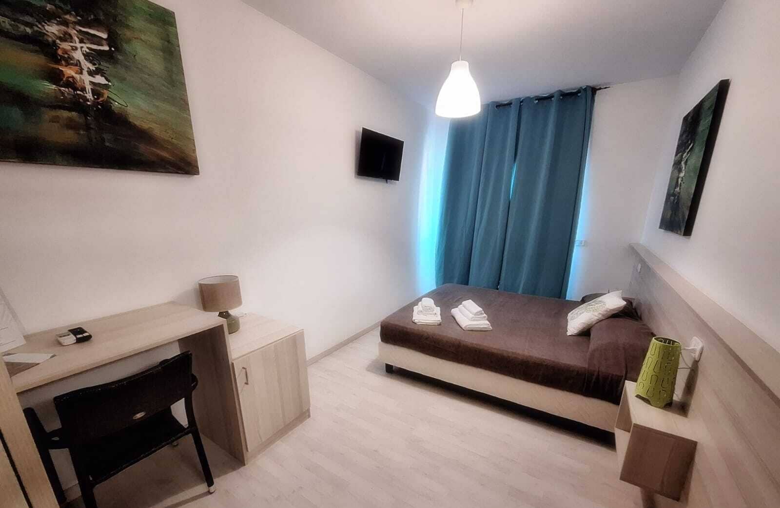 A modern bedroom with a bed, a desk, and a chair.