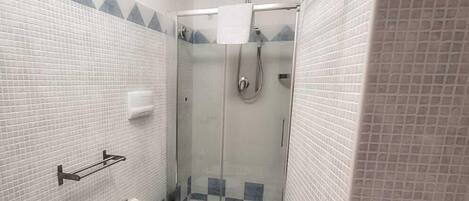 Baño con ducha, inodoro, bidé y piso de baldosas.
