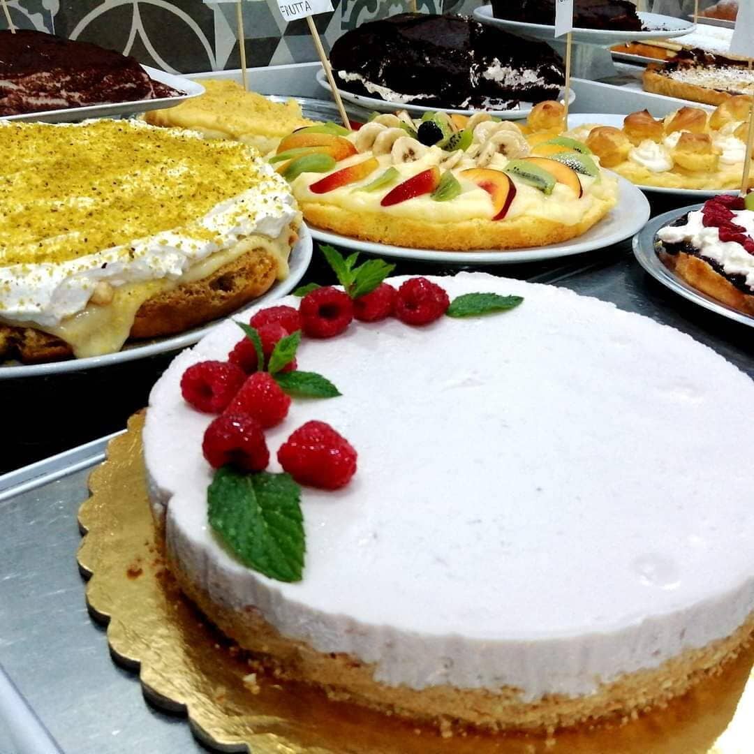 Variedad de postres a la vista, incluyendo un pastel con frambuesas y hojas de menta.