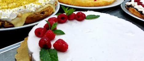 Variedad de postres a la vista, incluyendo un pastel con frambuesas y hojas de menta.