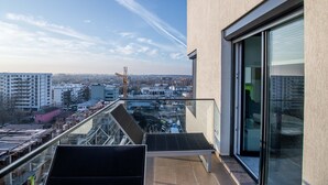 A balcony with a view of the city, a glass door, and a metal railing. - Luxury Westpark 2 Residence Lake View W2 (Bucharest)