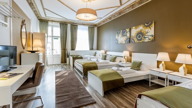 Hotellihuone, jossa on sänky, työpöytä ja televisio.
