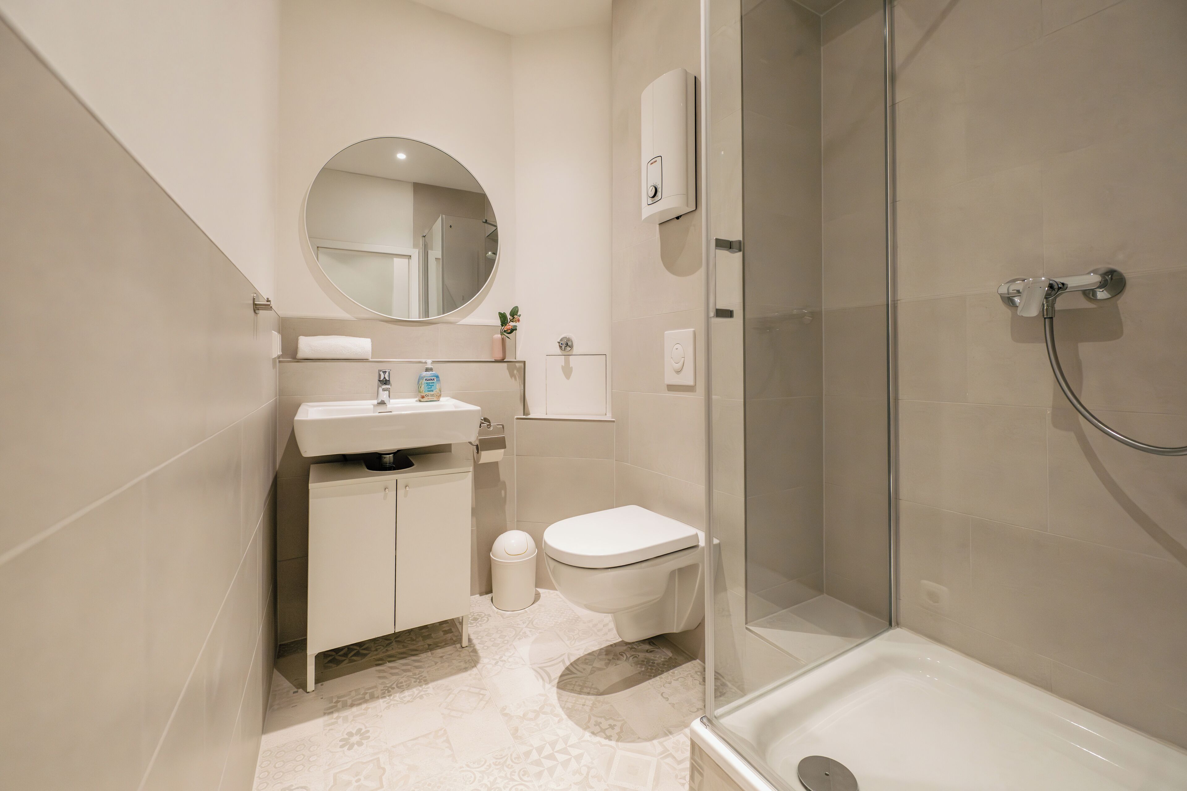 Une salle de bain moderne avec un lavabo, des toilettes et une douche.