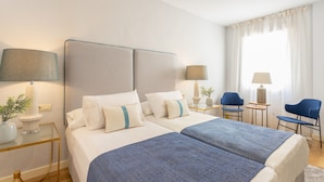 A hotel room with two beds, a desk, two chairs, and a window with curtains. - Genteel Home Francos Terrace VI (Sevilla)
