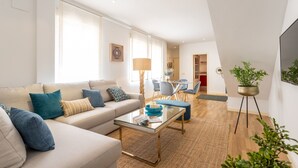 A modern living room with a sofa, coffee table, and a potted plant. - Genteel Home Francos Terrace VI (Sevilla)