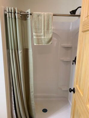Regadera, secadora de cabello, toallas, papel de baño 