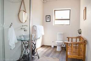 Bathroom features a glass-enclosed sink, wooden vanity, and toilet.