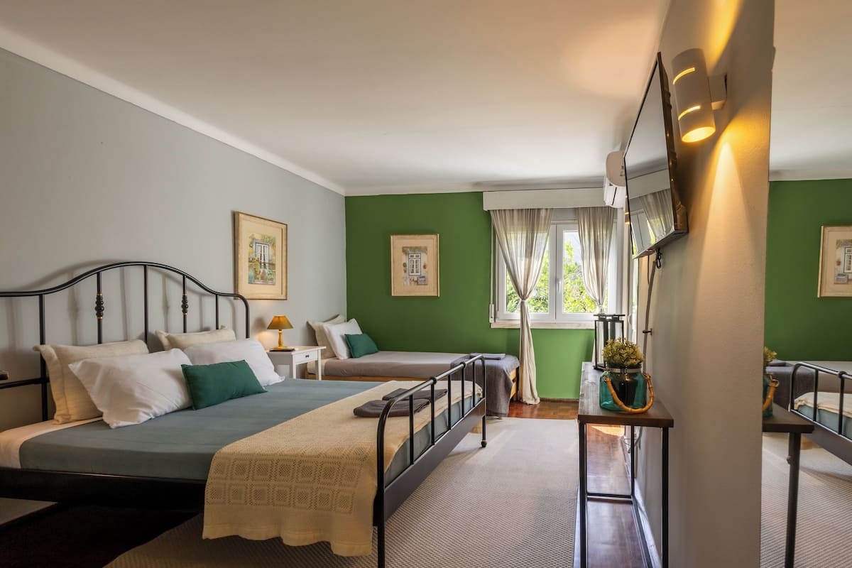Een slaapkamer met een bed, nachtkastje en een raam met gordijnen.
