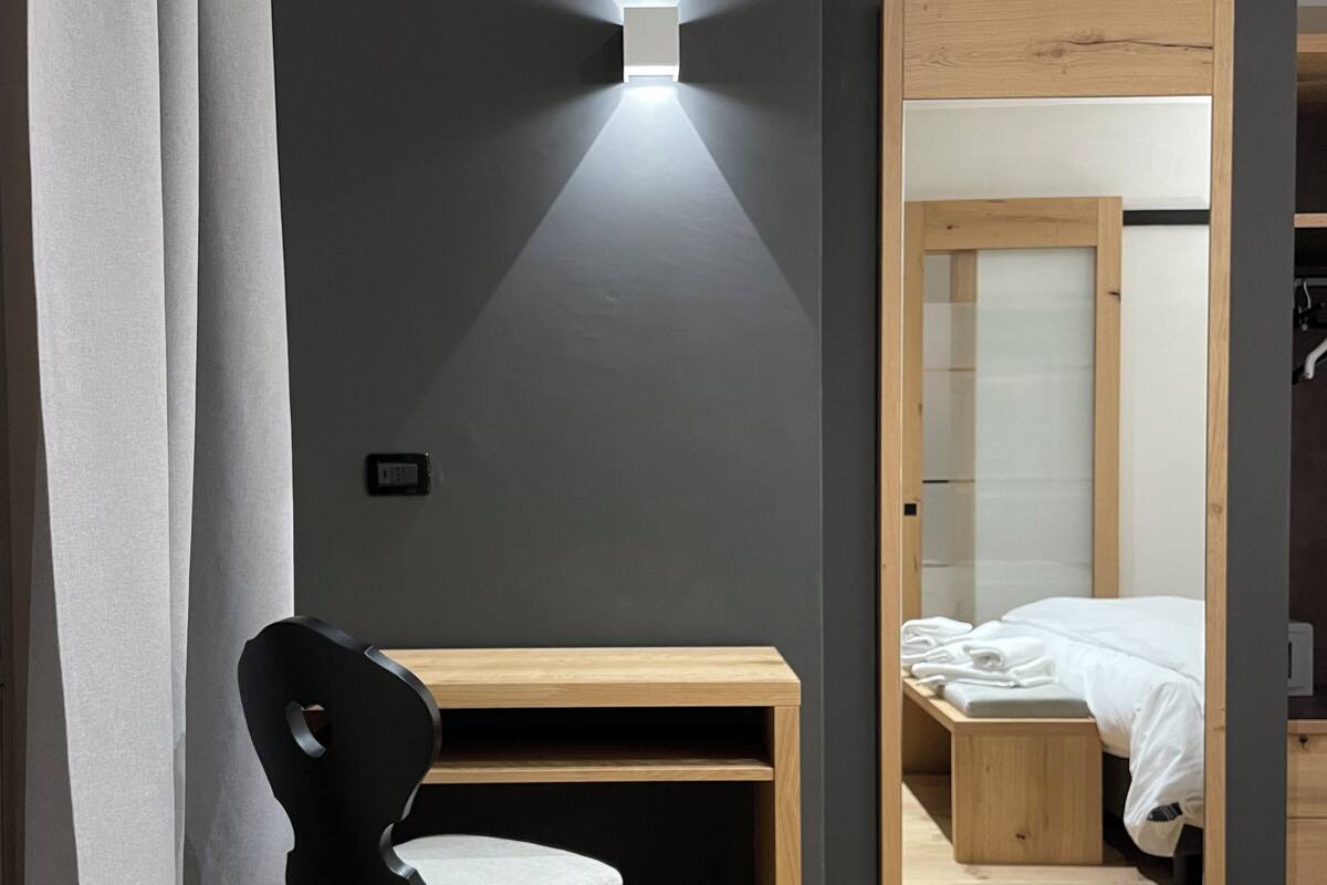 A modern room with a desk, chair, and bed.