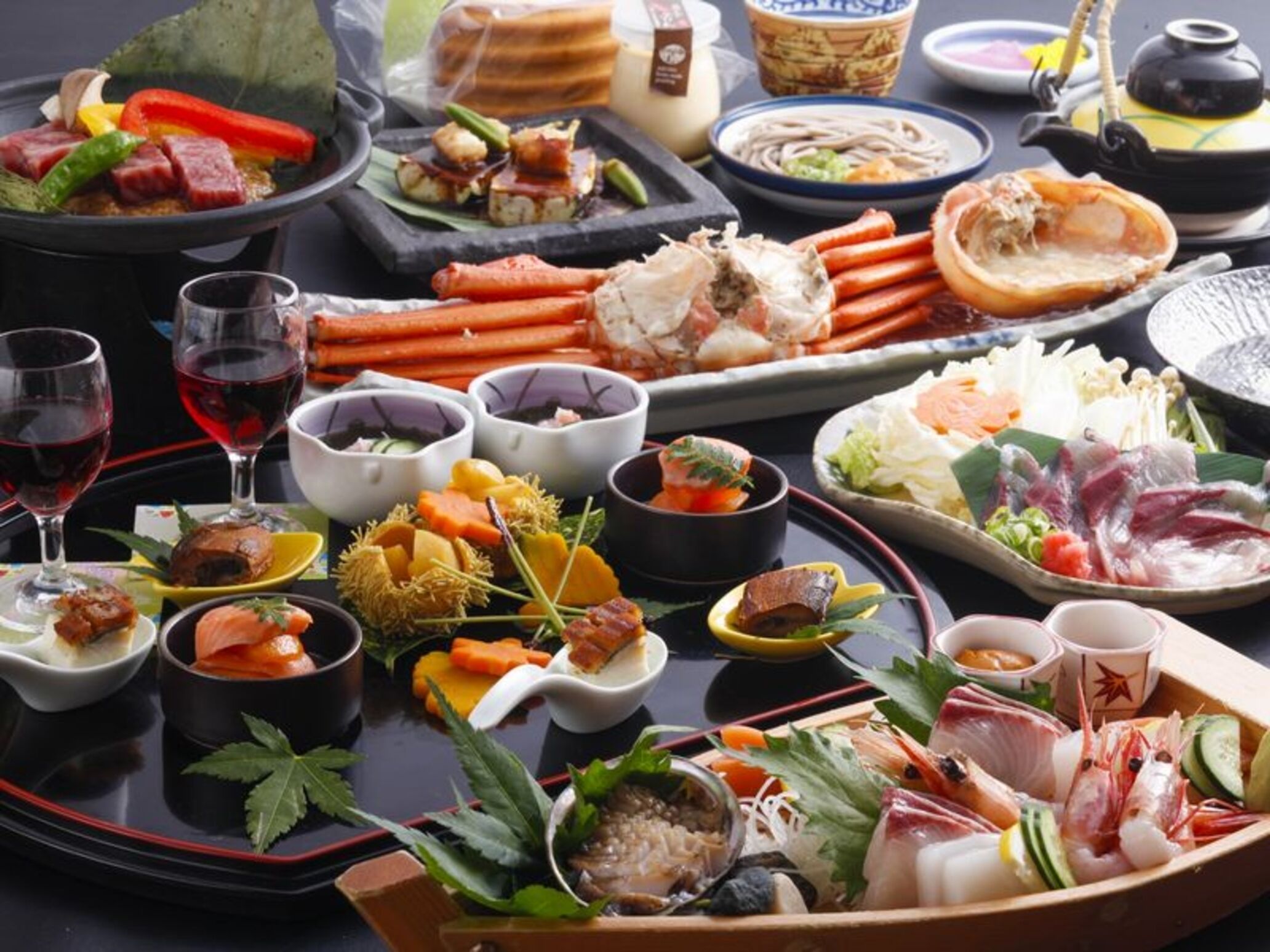 A variety of dishes and drinks on a table, including seafood, vegetables, and possibly sushi.