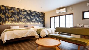 A hotel room with two beds, a bench, a round wooden table, and a large window with blinds. - Kinosaki Onsen Ryokan Oyado Hakusan (Toyooka)
