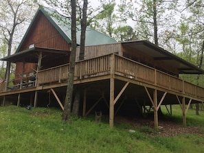A wooden cabin with a covered deck and a large window. - Remote getaway-the national forest-Direct access to the ATV trails- Wolf Pen Gap (Mena)