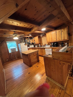 A wooden cabin kitchen with a central island, wooden cabinets, and a window with a view. - Remote getaway-the national forest-Direct access to the ATV trails- Wolf Pen Gap (Mena)